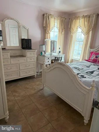 a bedroom with a bed dresser and a window