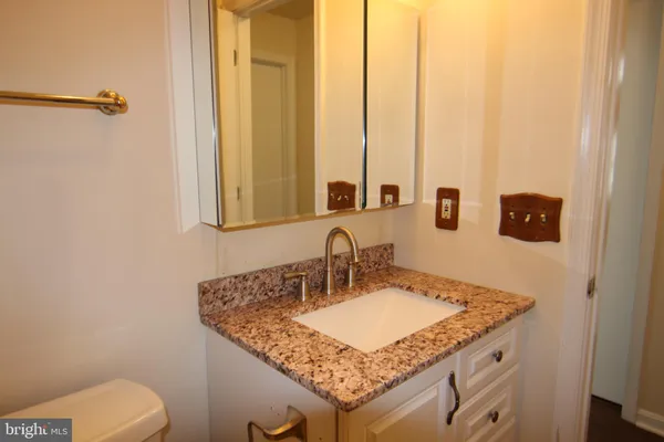 a bathroom with a granite countertop sink and a mirror