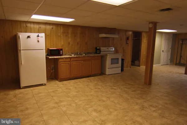 a view of a refrigerator in kitchen and a window