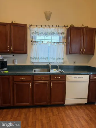 a kitchen with stainless steel appliances granite countertop wooden cabinets a sink and dishwasher