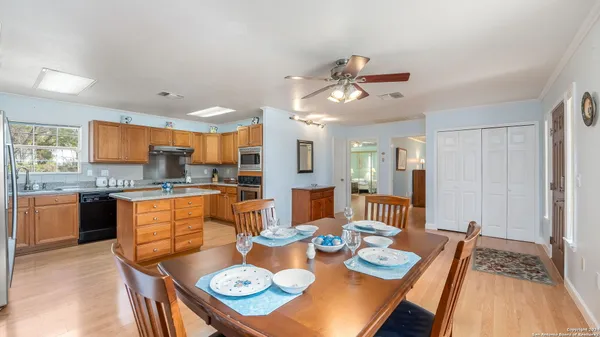 a open dining room with stainless steel appliances kitchen island granite countertop furniture and a kitchen view