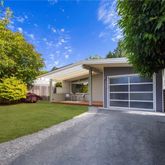 a view of a house with a yard and large tree