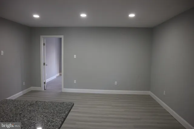 an empty room with wooden floor and a window