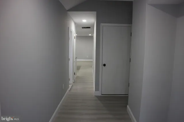 a view of a hallway with wooden floor