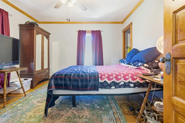 a bedroom with a bed a flat screen tv and a chandelier