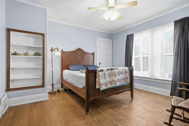 a bed sitting in a spacious bedroom next to a window