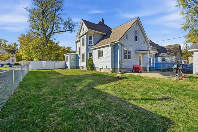 a front view of a house with a yard and trees