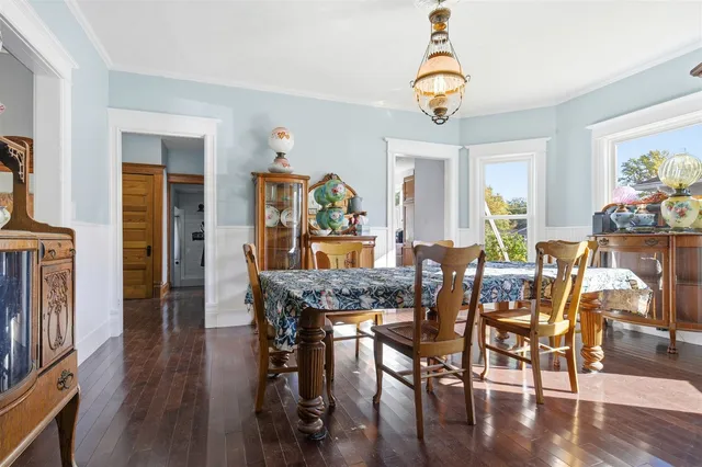 a dining room with furniture a chandelier and wooden floor