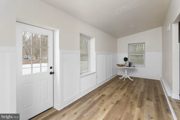 a view of a living room with wooden floor and a kitchen
