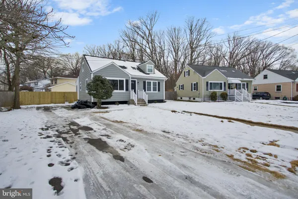 a front view of a house with a yard covered with snow