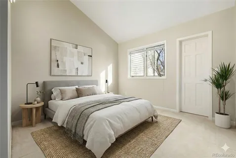 a bedroom with a large bed and a potted plant