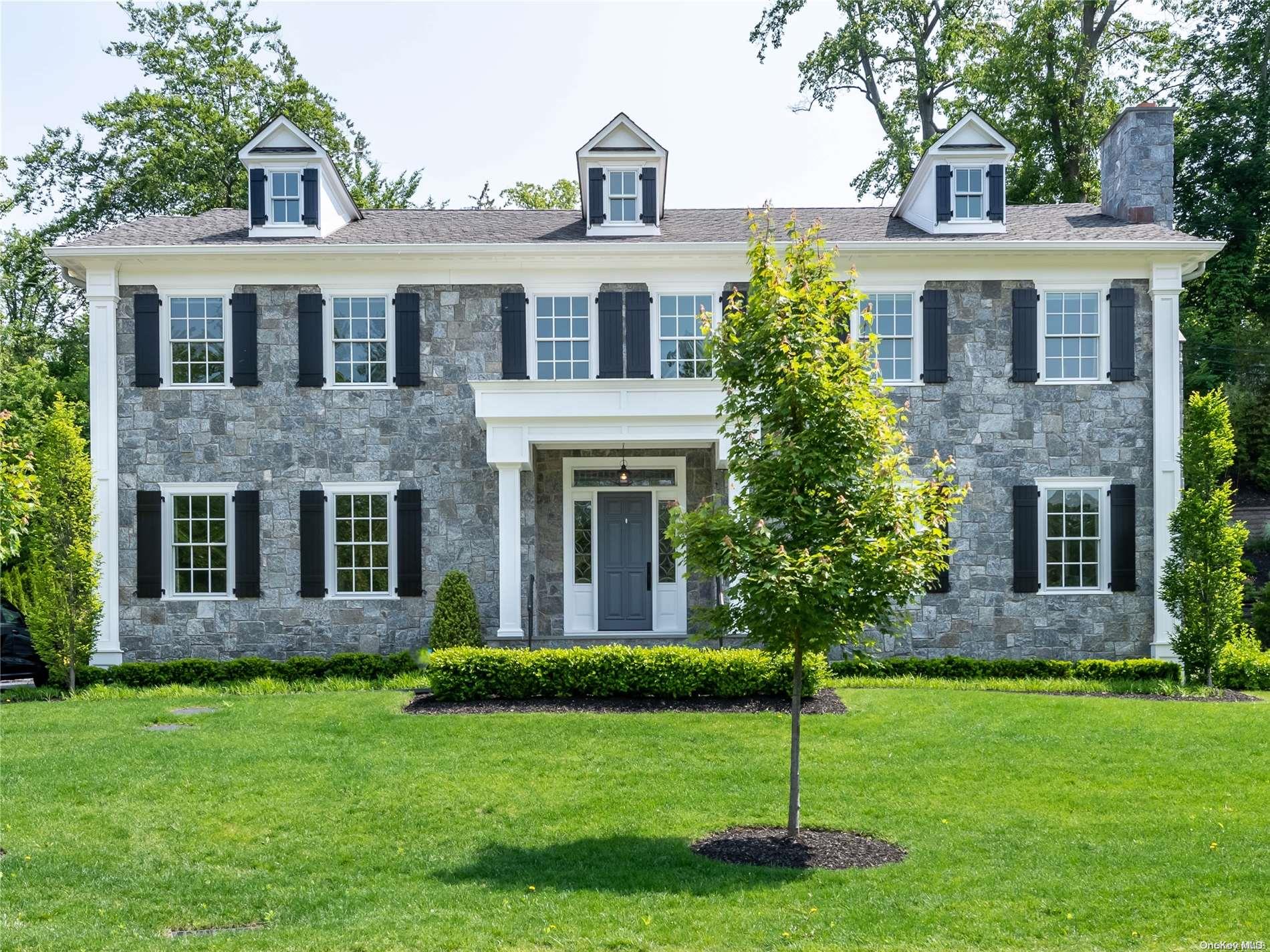 a front view of a house with a garden and yard