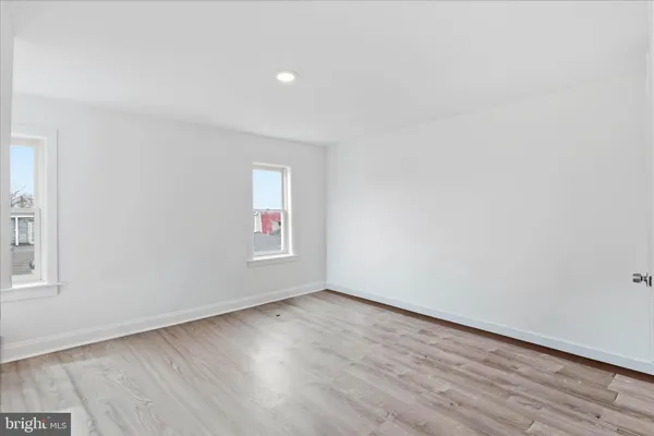 an empty room with wooden floor and window