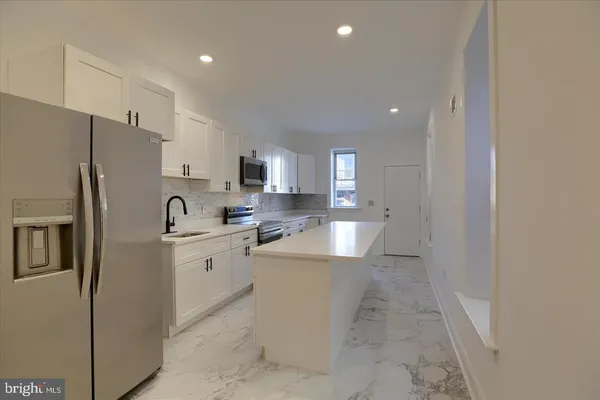 a kitchen with stainless steel appliances a refrigerator sink and microwave