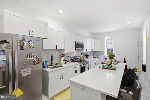 a kitchen with a sink a stove and white cabinets