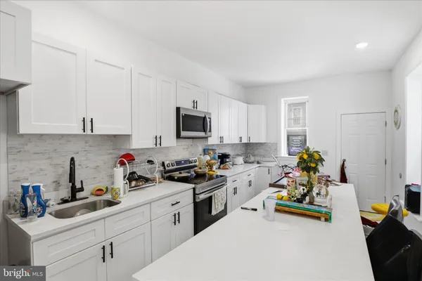 a kitchen with a sink a stove and cabinets