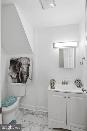 a bathroom with a granite countertop toilet sink and mirror