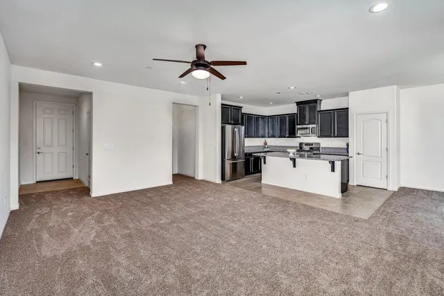 a kitchen with granite countertop kitchen island a sink stainless steel appliances and a counter space