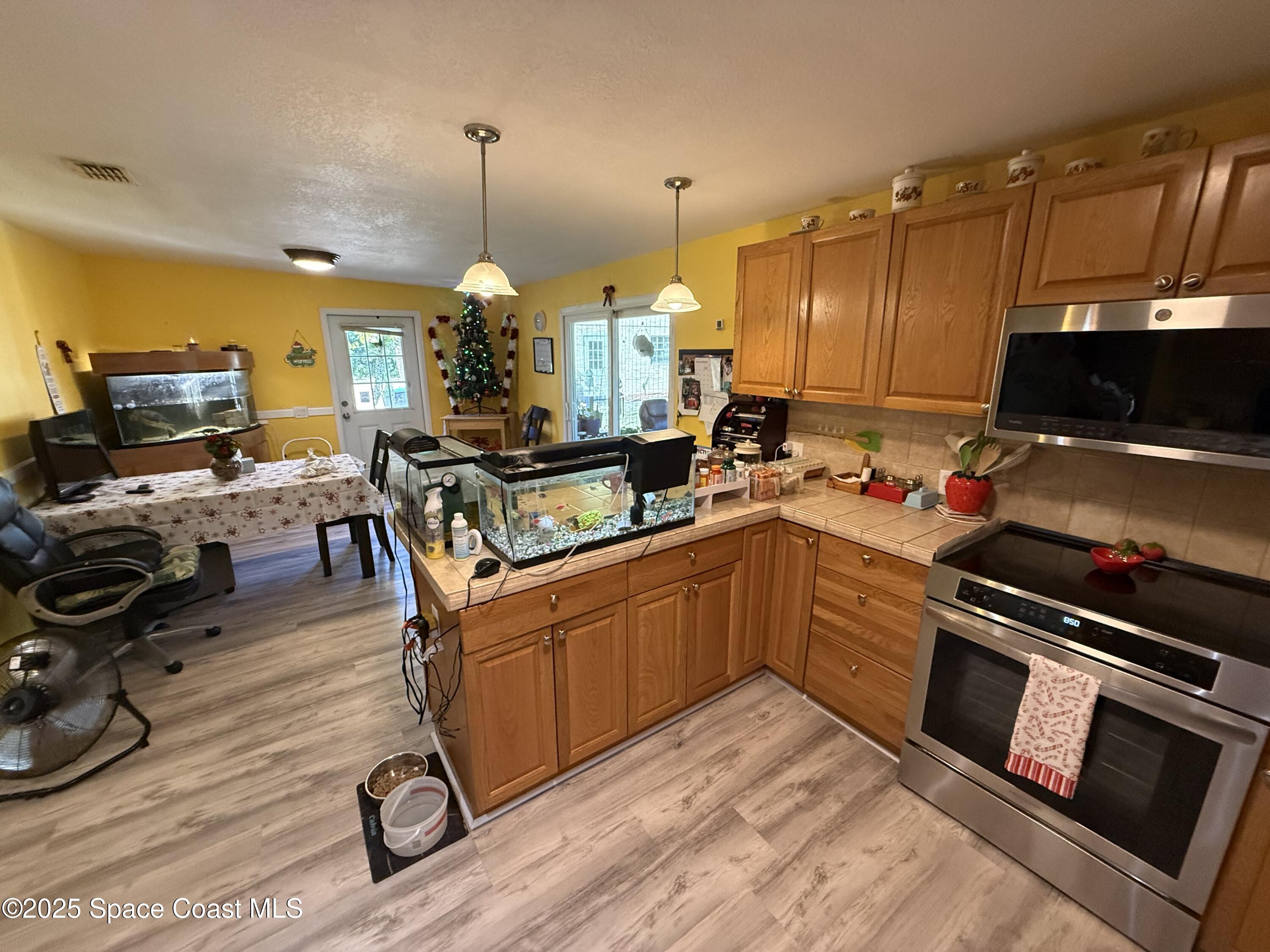 649 Waterside Road Southeast Palm Bay, FL 32909 - Photo 7 of 24 a kitchen with stainless steel appliances a stove a sink dishwasher and a microwave