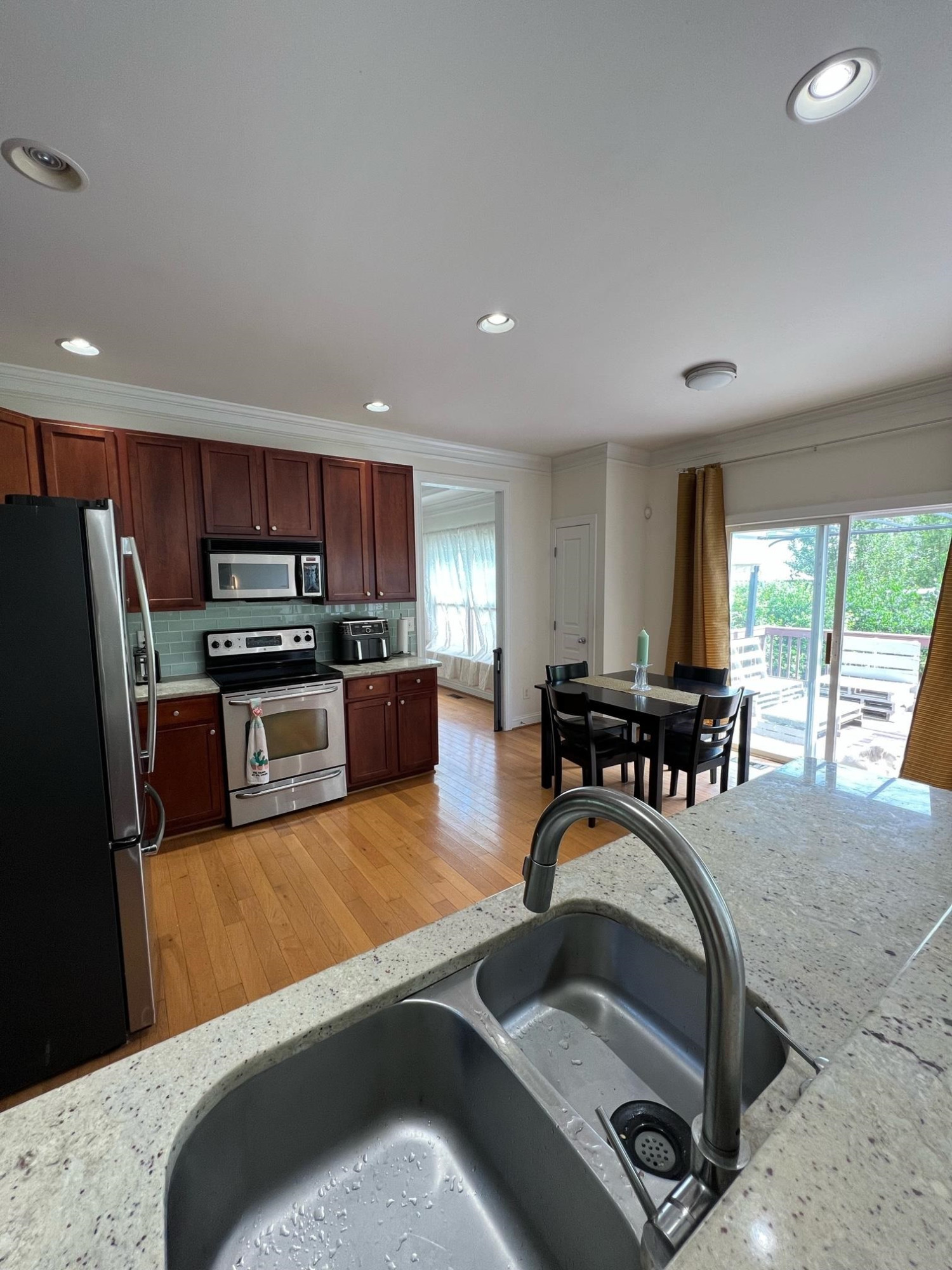 5807 Catskill Court Durham, NC 27713 - Photo 3 of 20 a kitchen with stainless steel appliances granite countertop a refrigerator a stove a sink a dining table and chairs with wooden floor