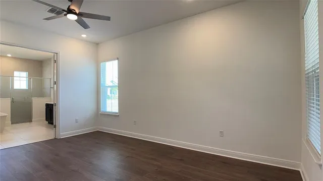 an empty room with wooden floor and white walls