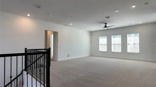 an empty room with a window and a ceiling fan