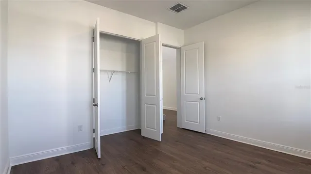 an empty room with windows and closet