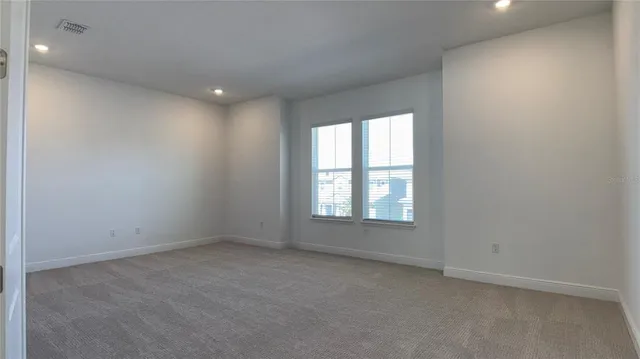 an empty room with windows and closet