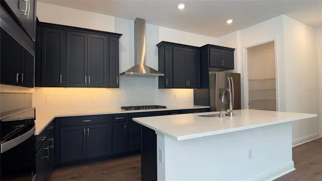 a kitchen with stainless steel appliances a sink and a refrigerator
