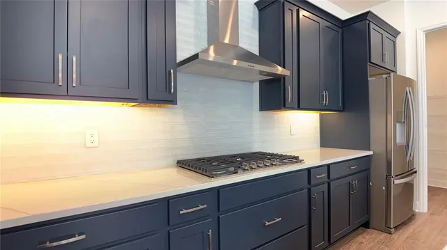 a kitchen with stainless steel appliances granite countertop a sink a stove and a refrigerator