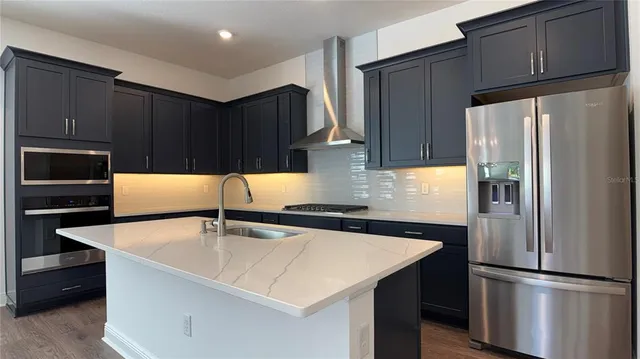 a view of an empty room with wooden floor and a ceiling fan