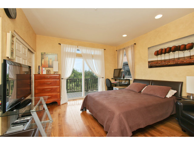 538 Monterey Road, Unit A Pacifica, CA 94044 - Photo 7 of 18 a bedroom with a bed a flat screen tv and balcony