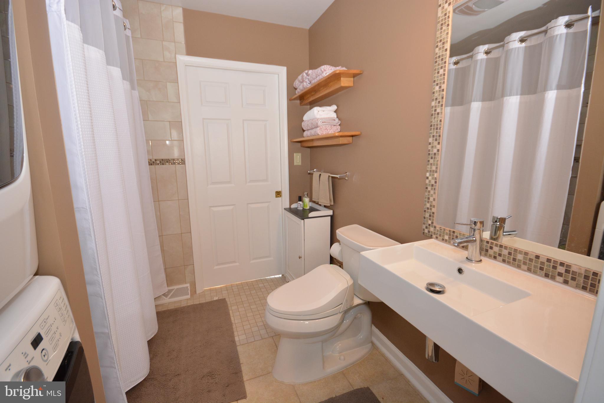 213 Bomberger Road Akron, PA 17501 - Photo 14 of 38 a bathroom with a sink a toilet and shower curtain