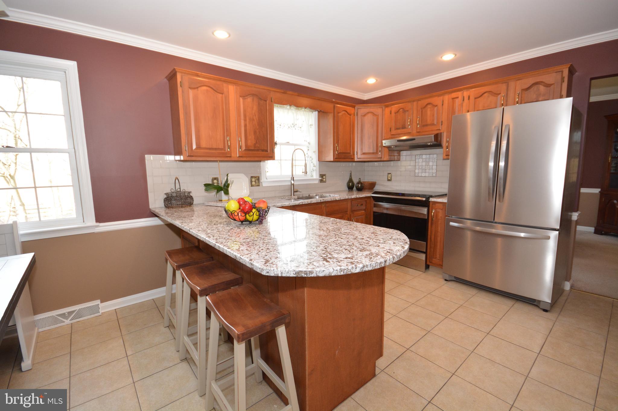 213 Bomberger Road Akron, PA 17501 - Photo 9 of 38 a kitchen with stainless steel appliances granite countertop a sink refrigerator and microwave