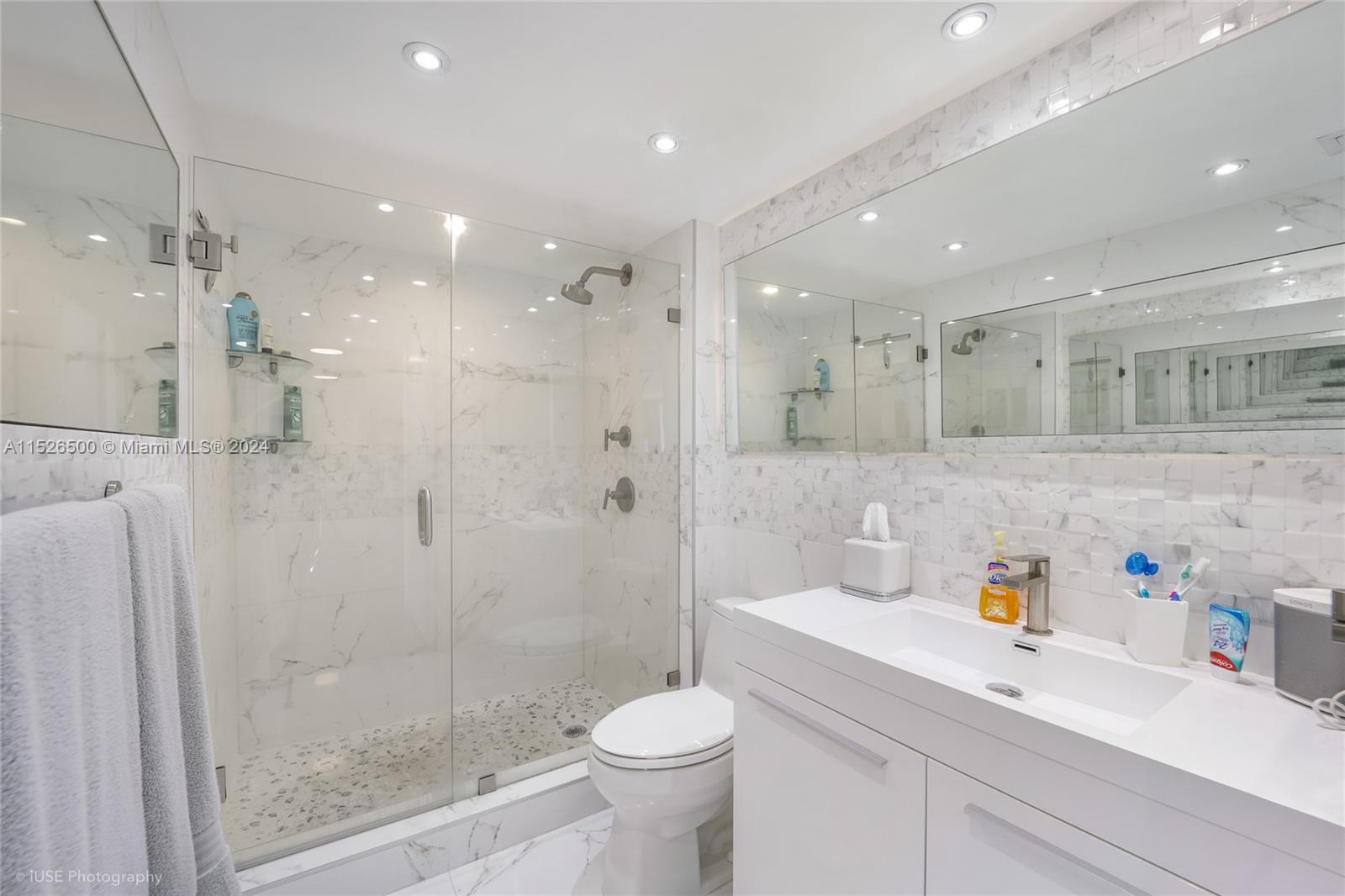 90 Alton Road, Unit 2806 Miami Beach, FL 33139 - Photo 14 of 18 a bathroom with a sink a toilet a shower and a mirror