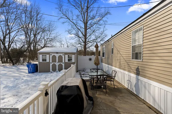 a view of a patio with table and chairs and wooden fence