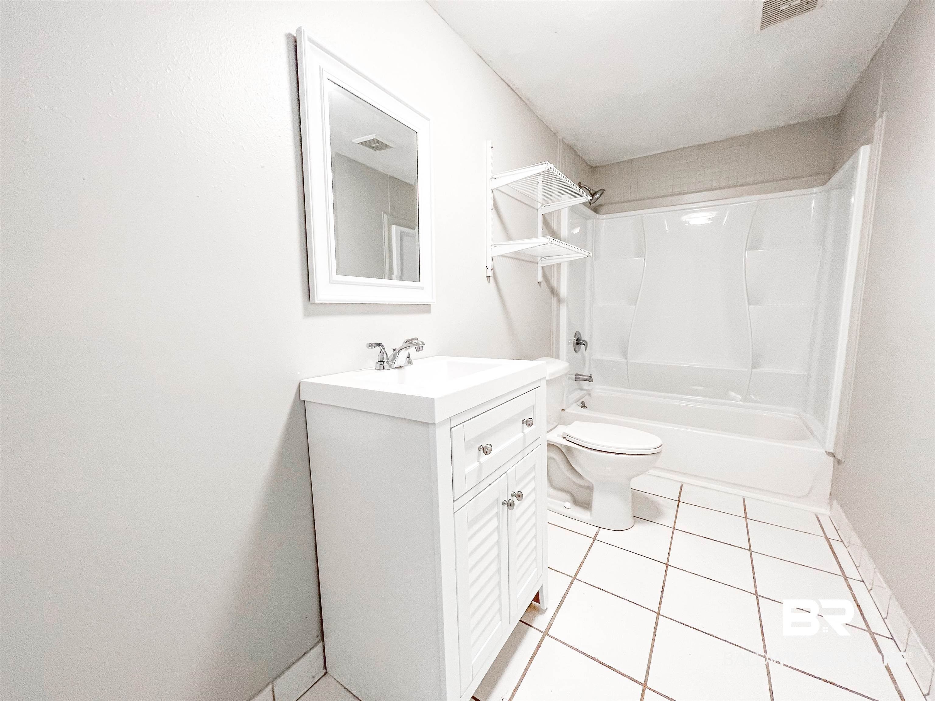 1164 Seneca Street Mobile, AL 36605 - Photo 14 of 22 Full bathroom featuring tile patterned flooring, toilet, visible vents, vanity, and washtub / shower combination