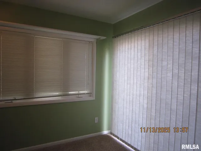 an empty room with a ceiling fan and a window
