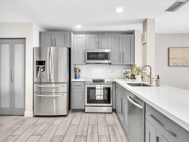 a kitchen with granite countertop a refrigerator and a sink