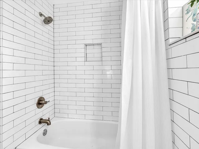 a bedroom with a bed chandelier and a window