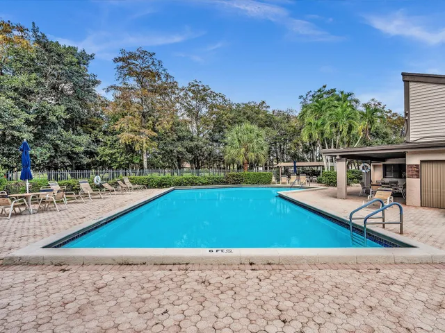 a view of yard with swimming pool and trees in the background