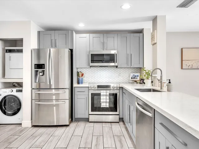 a kitchen with white cabinets and sink