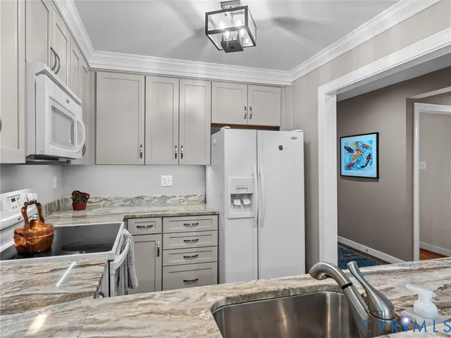 a kitchen with stainless steel appliances granite countertop a refrigerator and a stove top oven