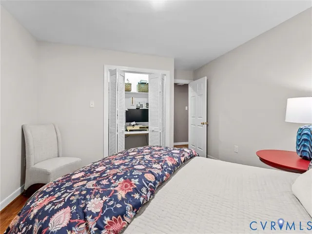 a bedroom with a bed and a lamp on dresser