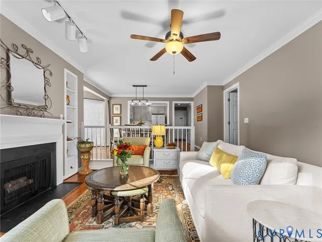 a living room with furniture a fireplace and a ceiling fan