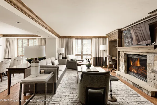 a living room with furniture a fireplace and a floor to ceiling window