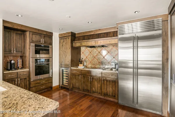 a kitchen with stainless steel appliances granite countertop a refrigerator and a stove top oven