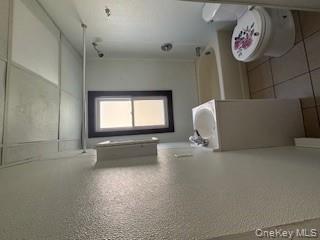 3 Dean Place Poughkeepsie, NY 12601 - Photo 6 of 10 Bathroom featuring vanity, light tile patterned flooring, shower combination, and a textured wall