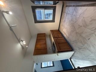 3 Dean Place Poughkeepsie, NY 12601 - Photo 7 of 10 Kitchen featuring brown cabinetry, track lighting, light countertops, light marble finish floors, and fridge