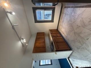 3 Dean Place Poughkeepsie, NY 12601 - Photo 8 of 10 Kitchen featuring brown cabinets, rail lighting, fridge, light countertops, and light marble finish flooring